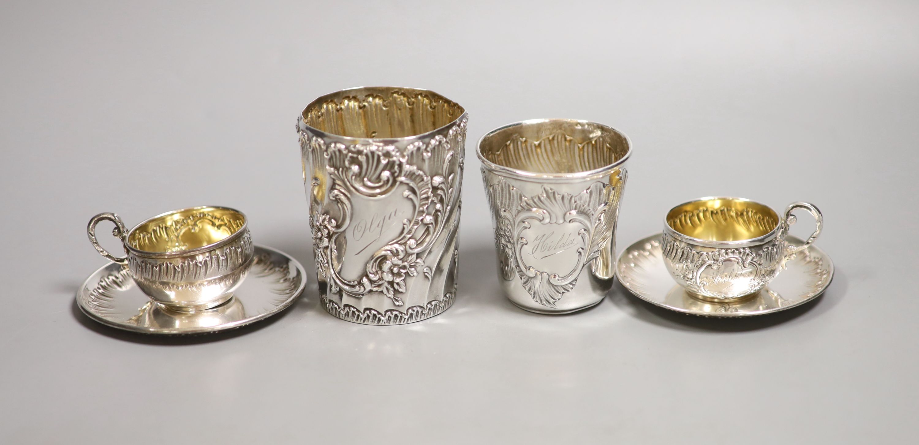 A pair of French white metal cups and saucers and two similar tumblers